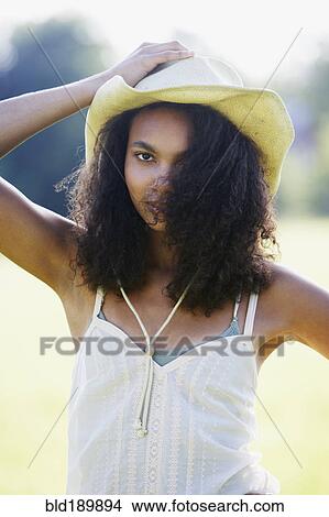Picture - Portrait of African woman wearing straw hat outdoors. Fotosearch