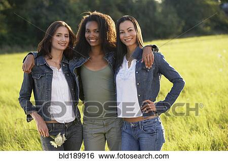 Portrait of three women hugging in meadow View Large Photo Image Stock Photograph - Portrait of three women hugging in meadow. Fotosearch
