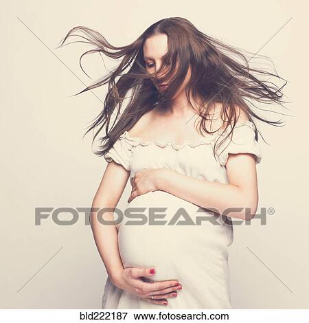 Stock Photo - Pregnant Caucasian woman hugging her belly. Fotosearch