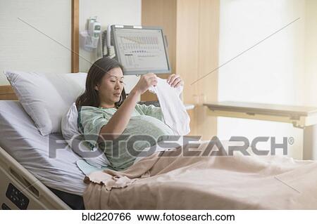 Stock Photograph - Pregnant Chinese woman in hospital bed. Fotosearch