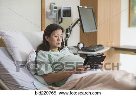 Pregnant Chinese woman in hospital room using digital tablet View Large Photo Image Stock Photography - Pregnant Chinese woman in hospital room using digital tablet. Fotosearch