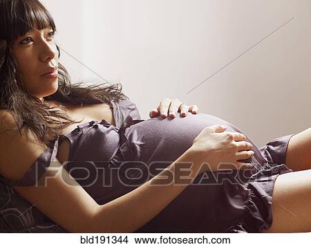 Picture - Pregnant mixed race woman relaxing. Fotosearch