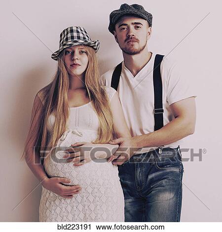 Stock Image - Pregnant woman and boyfriend hugging. Fotosearch