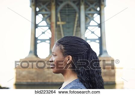 Picture - Profile of smiling Black woman at bridge. Fotosearch
