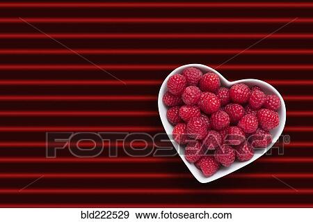 Raspberries in heart-shape bowl on red striped background View Large Photo Image Stock Photo - Raspberries in heart-shape bowl on red striped background. Fotosearch