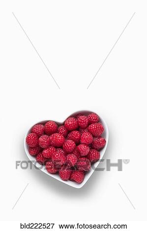 Stock Photo - Raspberries in heart-shape bowl on white background. Fotosearch