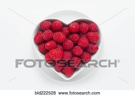 Stock Photo - Raspberries in heart-shape bowl on white background. Fotosearch
