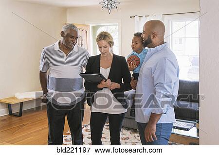 Stock Photo - Real estate agent and clients using digital tablet. Fotosearch
