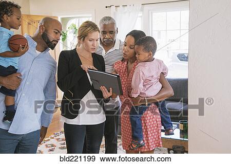 Stock Photo - Real estate agent and clients using digital tablet. Fotosearch