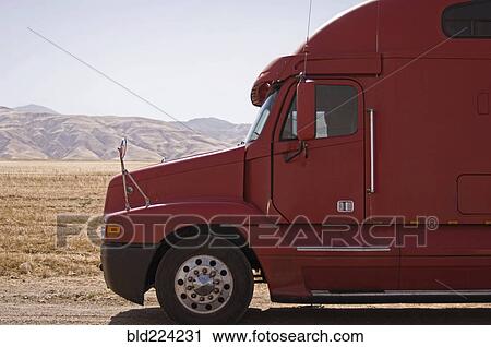 Stock Image - Red semi-truck against mountains. Fotosearch
