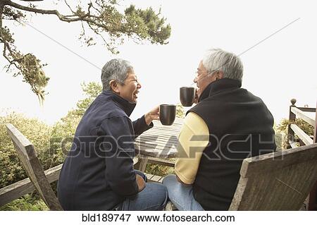 Senior Asian couple drinking coffee outdoors View Large Photo Image Stock Photo - Senior Asian couple drinking coffee outdoors. Fotosearch