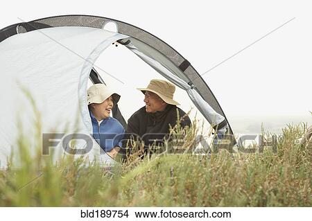 Senior Asian couple sitting in tent smiling View Large Photo Image Picture - Senior Asian couple sitting in tent smiling. Fotosearch