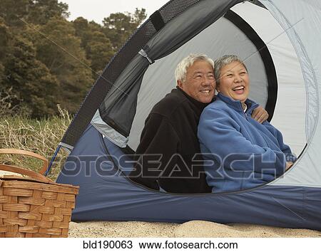Senior Asian couple sitting in tent smiling View Large Photo Image Stock Image - Senior Asian couple sitting in tent smiling. Fotosearch