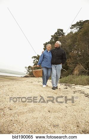 Senior Asian couple walking on beach with picnic basket View Large Photo Image Stock Photography - Senior Asian couple walking on beach with picnic basket. Fotosearch