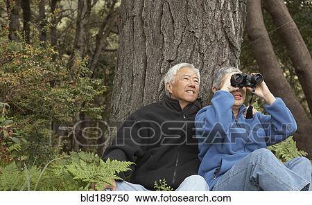 Senior Asian couple with binoculars outdoors View Large Photo Image Stock Image - Senior Asian couple with binoculars outdoors. Fotosearch