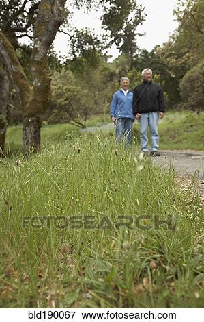 Stock Photo - Senior couple holding hands outdoors. Fotosearch