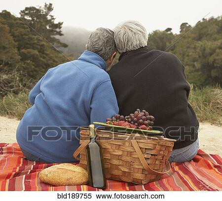 Stock Photography - Senior couple hugging at picnic. Fotosearch