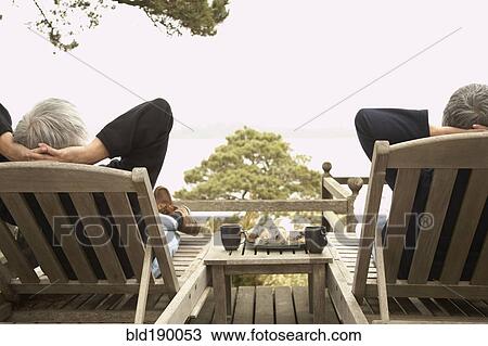 Stock Image - Senior couple relaxing in deck chairs. Fotosearch