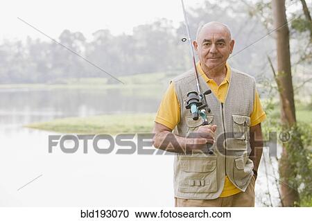 Stock Image - Senior Hispanic man fishing. Fotosearch