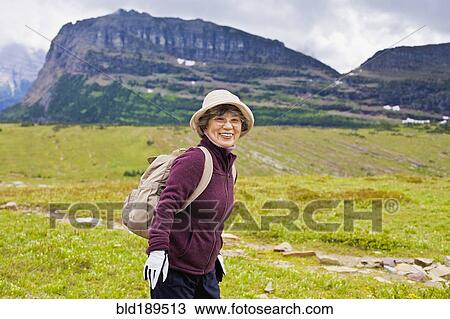 Stock Image - Senior Japanese woman hiking. Fotosearch