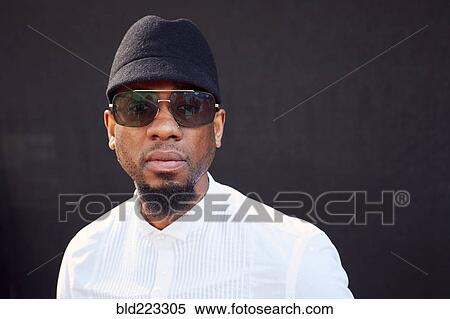 Stock Photography - Serious African American man wearing sunglasses and hat. Fotosearch