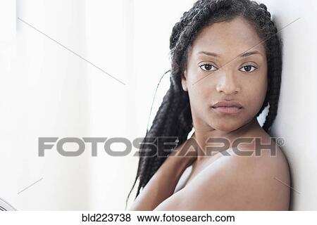 Stock Photo - Serious Black woman leaning on wall. Fotosearch
