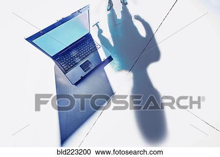 Shadow of hacker lurking over laptop computer View Large Photo Image Stock Image - Shadow of hacker lurking over laptop computer. Fotosearch