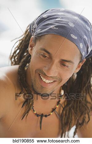 Stock Photography - Smiling, bare chested Hispanic man in headscarf. Fotosearch