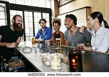 Stock Photography - Smiling bartender and customers at bar. Fotosearch