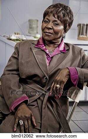 Smiling Black businesswoman sitting in office View Large Photo Image Stock Image - Smiling Black businesswoman sitting in office. Fotosearch