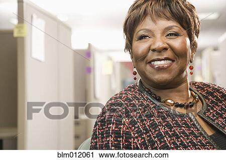 Smiling Black businesswoman standing in office View Large Photo Image Stock Image - Smiling Black businesswoman standing in office. Fotosearch
