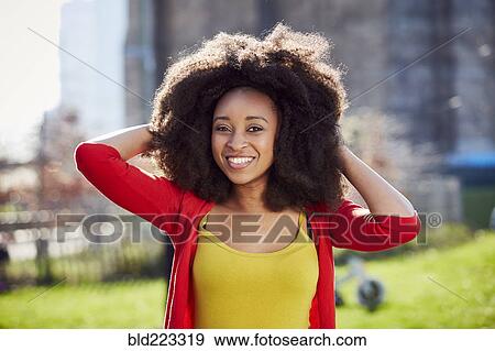 Stock Photo - Smiling Black woman posing at waterfront. Fotosearch