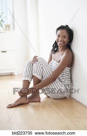 Smiling Black woman sitting on floor View Large Photo Image Stock Photography - Smiling Black woman sitting on floor. Fotosearch