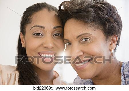 Stock Photography - Smiling Black women posing cheek to cheek. Fotosearch