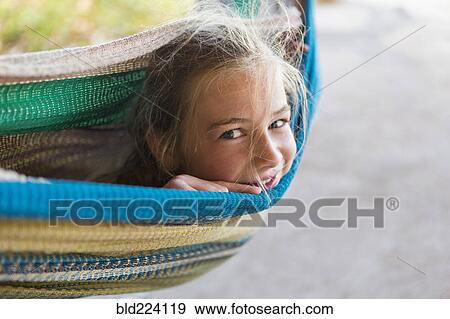 Stock Photo - Smiling Caucasian girl laying in hammock. Fotosearch