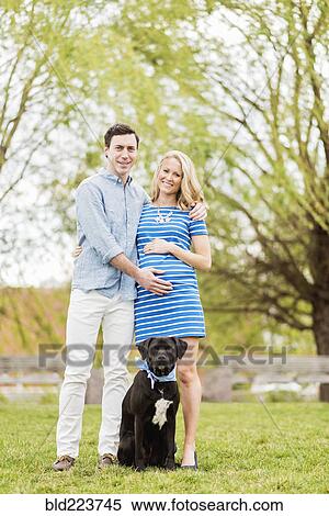 Smiling Caucasian man and expectant mother posing with dog in park View Large Photo Image Stock Photography - Smiling Caucasian man and expectant mother posing with dog in park. Fotosearch
