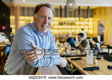 Smiling Caucasian man leaning on banister at restaurant View Large Photo Image Stock Image - Smiling Caucasian man leaning on banister at restaurant. Fotosearch