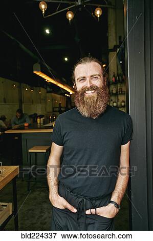 Smiling Caucasian man with beard leaning in doorway View Large Photo Image Stock Photo - Smiling Caucasian man with beard leaning in doorway. Fotosearch