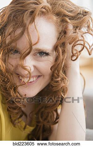 Stock Photography - Smiling Caucasian with hand in hair. Fotosearch