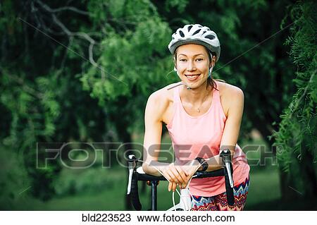 Smiling Caucasian woman leaning on bicycle handlebar View Large Photo Image Stock Image - Smiling Caucasian woman leaning on bicycle handlebar. Fotosearch