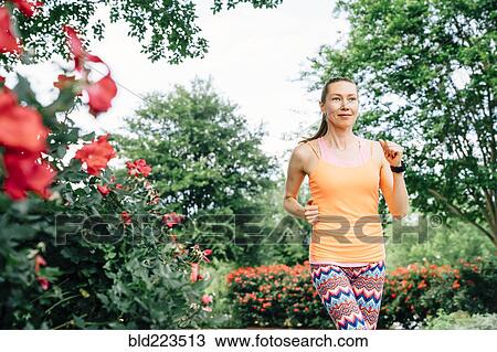 Stock Image - Smiling Caucasian woman running. Fotosearch