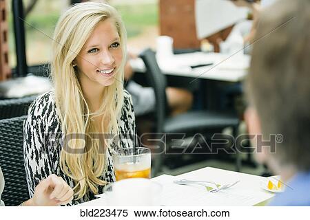 Smiling Caucasian woman sitting at restaurant table View Large Photo Image Stock Photography - Smiling Caucasian woman sitting at restaurant table. Fotosearch