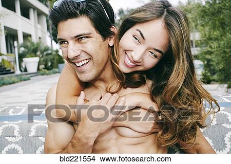 Picture - Smiling couple hugging outdoors. Fotosearch