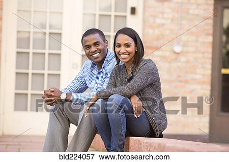 Stock Photo - Smiling couple sitting on steps. Fotosearch