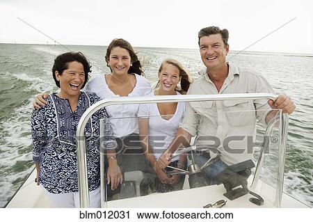Stock Image - Smiling family boating outdoors. Fotosearch