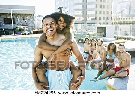 Stock Photography - Smiling friends enjoying urban swimming pool. Fotosearch