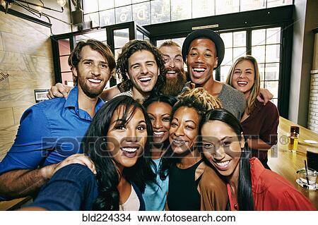 Picture - Smiling friends posing in bar. Fotosearch
