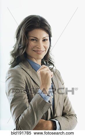 Stock Photography - Smiling Hispanic businesswoman holding eyeglasses. Fotosearch