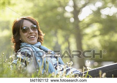 Smiling Hispanic woman laying in grass View Large Photo Image Stock Image - Smiling Hispanic woman laying in grass. Fotosearch