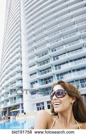 Smiling Hispanic woman poolside in sunglasses View Large Photo Image Stock Photo - Smiling Hispanic woman poolside in sunglasses. Fotosearch